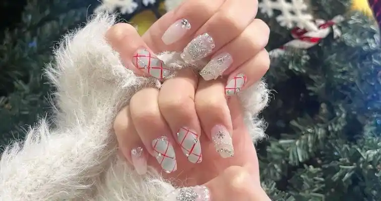 Cute Christmas nails with red and white nail art and silver glitters. 