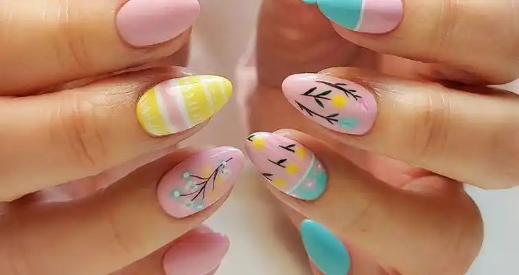 Cute easter nails with pastel blue, pink, and yellow nail colors, and easter eggs art.