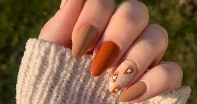 Thanksgiving nails with nude nail colors and pumpkin pie art. 