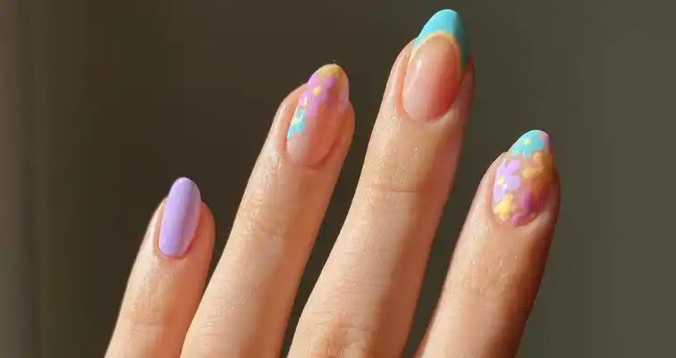 Spring manicure with pastel nail colors and flower art.