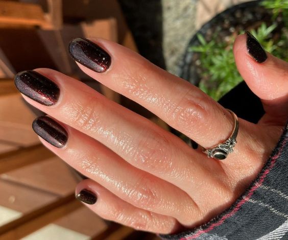 November nails with dark brown glitter nail color and round nail shape. 