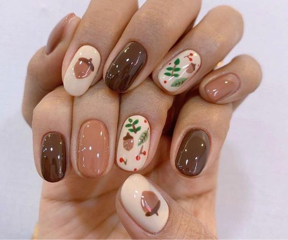 Harvest-themed nail art with nuts and leaves patterns