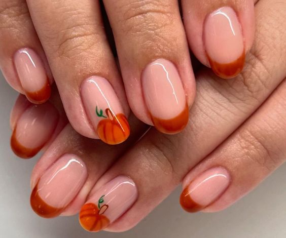 French manicure with orange color and pumpkin designs