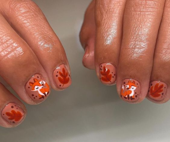 Cute harvest-themed art on matte red nails. 